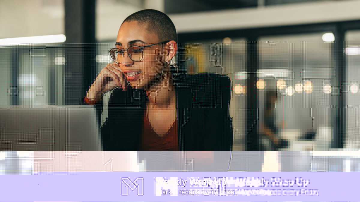 A business woman looking at her computer while resting her head on her right hand.