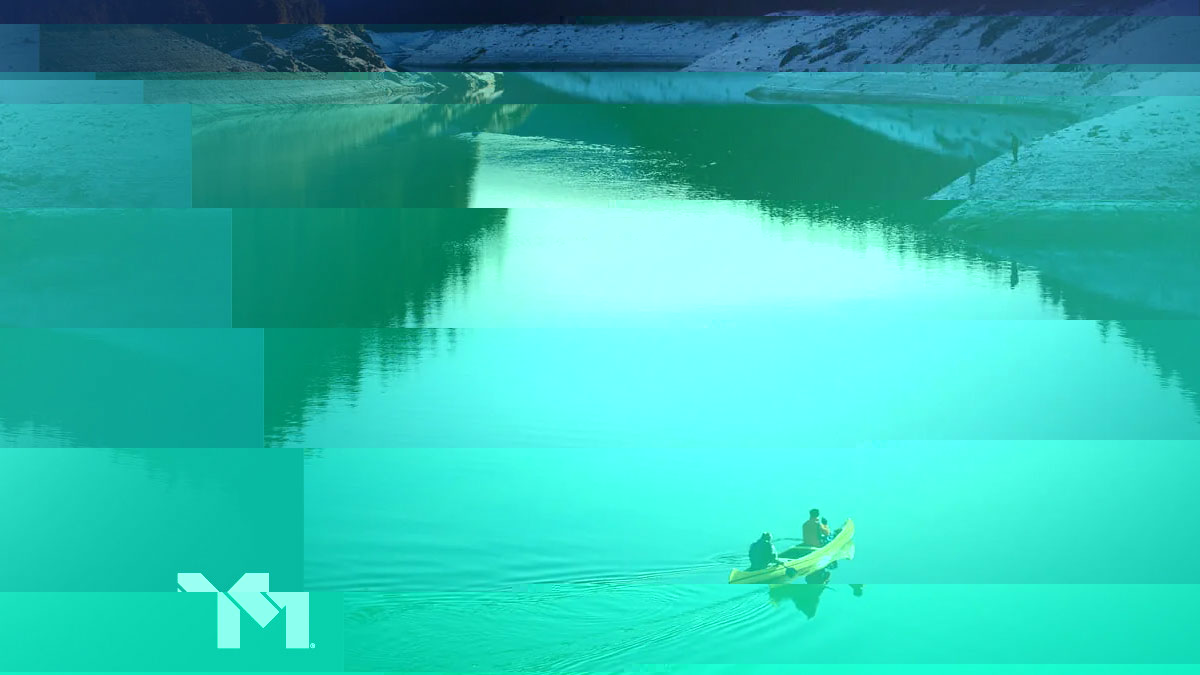 Two people paddling on a canoe down a wide lake.