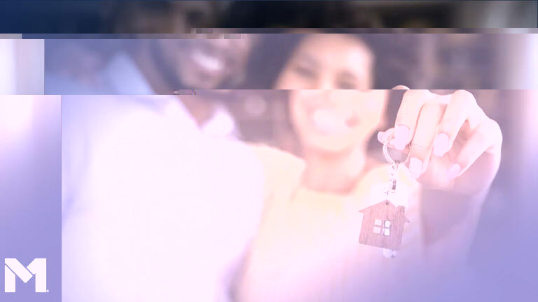 Two people holding up a set of keys with a house-shaped keychain attached to it, likely the keys to their new home.